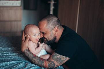 Tattooed bearded father playing with his son