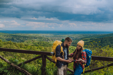 A couple of hikers using smartphone for orientation while spending time in nature