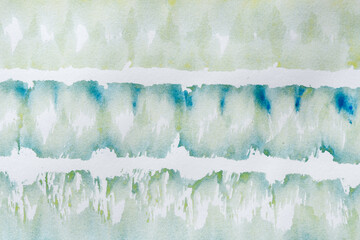 mixed yellow green blue and some orange watercolour background on white uneven paper