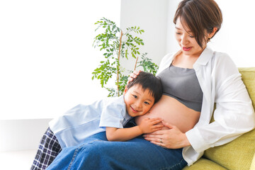 赤ちゃんの鼓動を聞く小さな男の子