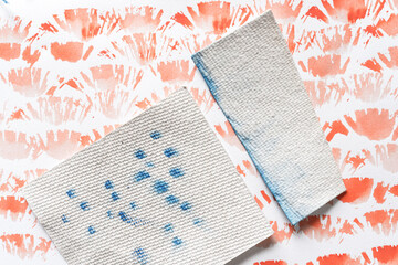 random, abstract watercolor background in cadmium orange red with pieces of textured paper stained...