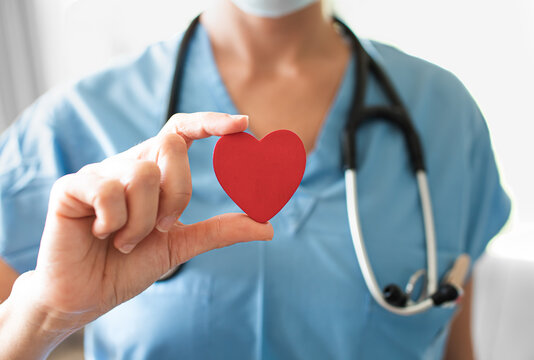 Nurse Medical Worker Holding Up Red Heart. Healthcare And Medical Health Concept. 