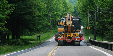 A truck carrying an oversize load is heading toward an oncoming car on Route 79 in the small town...