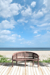 白いデッキに木のベンチ、午後のビーチリゾート