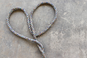 Ship ropes tied to knot, isolated on cement flooring background closeup.