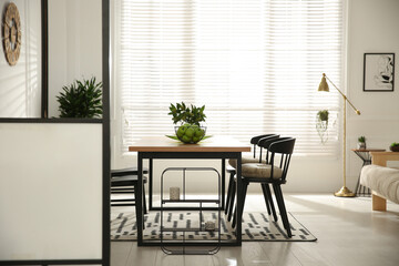 Stylish wooden dining table and chairs in room. Interior design