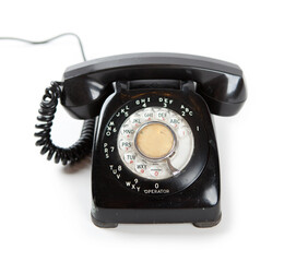 Old Late 60s - 70s style black telephone with rotary dial. Isolated on white. 