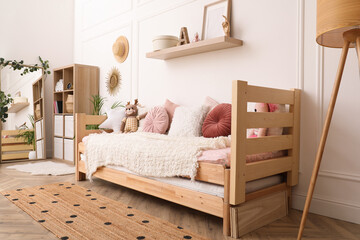 Cute child's room interior with comfortable bed and toys - obrazy, fototapety, plakaty