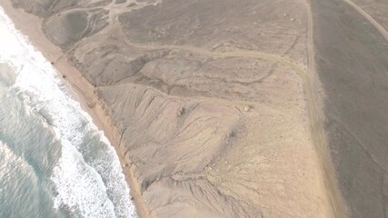 Shooting from sport fpv drone buggy cars fast skill driving on coast shore with waving water at sunset in summer day. Aerial follow shot extreme driving rally automobile on beach at nature landscape