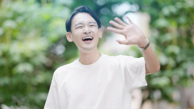 友人と待ち合わせをしている若い男性