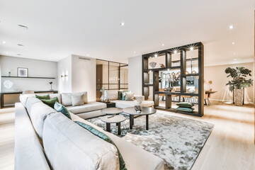 Armchairs and sofa placed around table in light living room of modern house