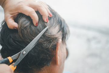 Wife cuts her husband's hair at home in a pandemic situation.