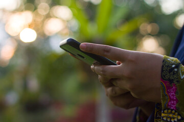 Muslim Woman typing with her smartphone