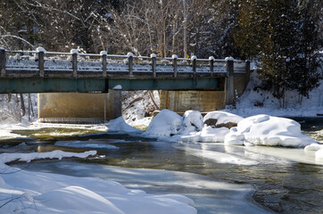 Metal Bridge Over Flowing River in Winter