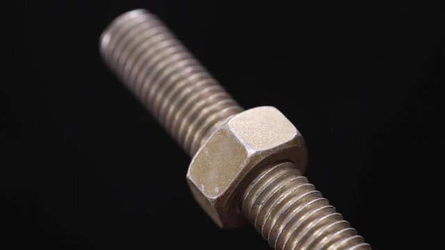 The steel nut turns the thread on the long screw back and forth close up