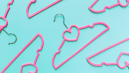 Black Friday or clothing industry concept on blue background with pink hangers
