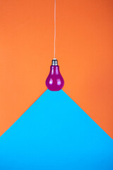 Geometric still life with purple light bulb on wire