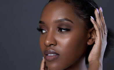 Fototapeta premium portrait of Smiling black beauty on black background, with attractive healthy smooth skin, shiny, clean and pure. Women beauty and make up, black copy space