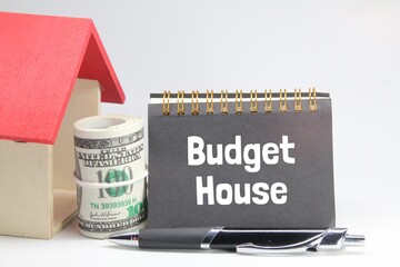 house models, pens, notebooks and rolls of paper money with the word budget house