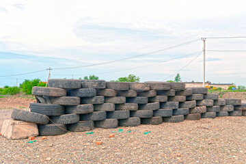 A pyramid of old, worn out car tires. In the open air