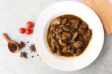Chicken Liver Masala or Kaleji fry garnished with coriander. Liver fry is a very popular Nonvegetarian Indian dish. Made from Chicken liver. White background. copy space with spices.