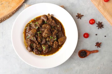 Chicken Liver Masala or Kaleji fry garnished with coriander. Liver fry is a very popular Nonvegetarian Indian dish. Made from Chicken liver. White background. copy space with spices.