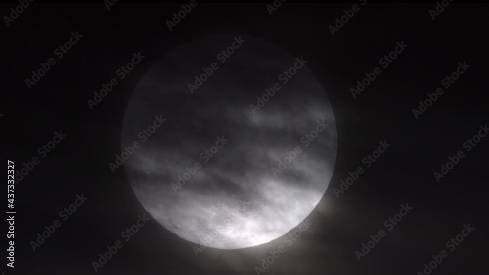 Wall mural zoomed in view of a super full moon with eerie, wispy clouds partially obscuring it