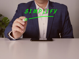 Manager writing SIMPLIFY on a transparent virtual interface with a marker pen