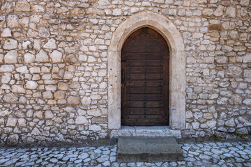 Arched Wooden Door in Old Stone Castle Wall
