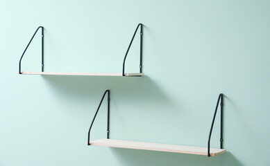 Modern shelves hanging on color wall