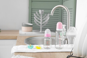 Clean baby bottles on table near sink
