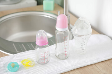 Clean baby bottles on table near sink