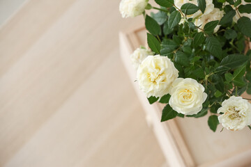 Beautiful white roses in pot on table, closeup