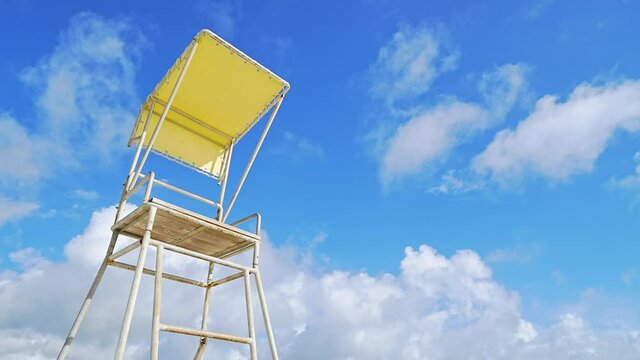 夏雲を背景にしたライフガードの椅子。動画は5倍速。コピースペースあり。