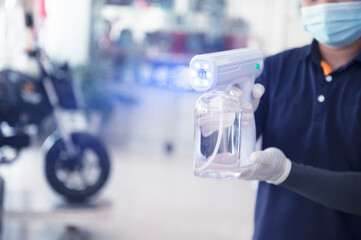 Motorcycle showroom workers spray disinfectants and germs that adhere to objects on the surface. Prevent infection with Covid 19 or coronavirus