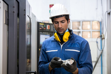 Workers inspecting workpieces from CNC machines. Engineer  Planning CNC Machinery Project