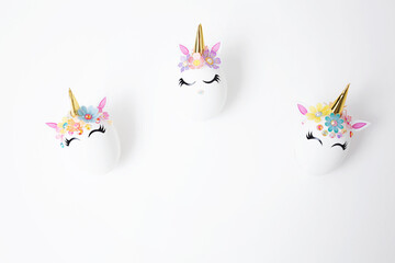 Easter eggs decorated with unicorn stickers on a white background. Copy space. funny unicorns. Top view. Background for Easter.