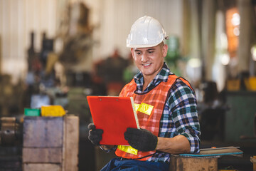 man Lathe worker in production plant drilling at machine on the factory. Industrial engineer worker holding notebook Inspect workpieces