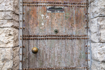 Ancient stone wall with a gate in the old castle.