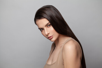 Fototapeta premium Healthy young brunette model woman with smooth straight hair and clear skin. Skincare, haircare and facial treatment concept