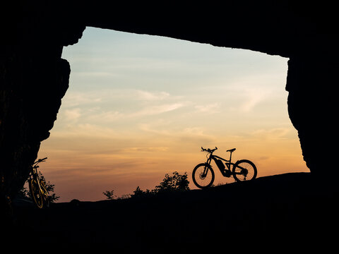 silhouette of a bicycle or e-bike in a cave at sunset