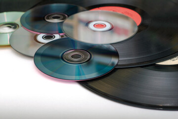 vinyl discs and CDs on a white surface concept storage of information progress