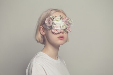 Young girl with closed eyes and roses flowers on white background