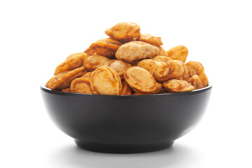 close-up of Roasted Crunchy Peanuts in a ceramic black bowl, made with peanuts. Pile of Indian spicy snacks (Namkeen),