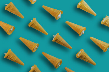 Waffle cones with white sweet filling on a green background. Sweet waffle cones with filling. The image of a sweet treat.