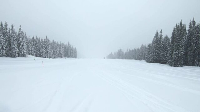 skiing in the mountains while snowing