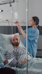 Medical team monitoring patient vital checking heart rate injecting fluids in drip bag for...
