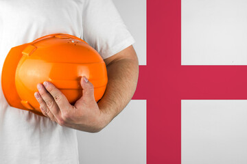 Worker with England flag on background for working on labor day. Construction concept.