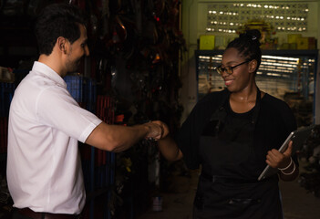 Woman bumping fist with man. Diversity of two people, black African worker woman bumping fist with caucasian business manager in factory-warehouse