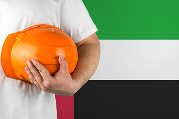 Worker with United Arab Emirates flag on background for working on labor day. Construction concept.